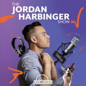 The cover art for The Jordan Harbinger Show. In front of a blue and purple gradient background, Jordan Harbinger is photographed adjusting the collar of his button-down shirt, standing 3/4 to the camera. In front of him is a microphone, behind him is headphones, and to his side is a hairless sphinx cat. The show's title is at the top in white all-caps sans-serif font, and the art has abstract squiggles in orange, evoking a nostalgic 90's aesthetic.